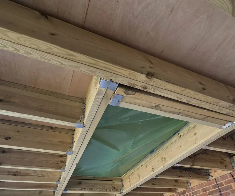 Extension roof under construction, with new joists framing the roof light opening