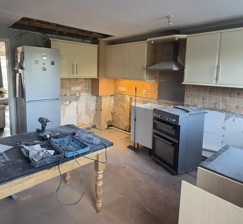 Old kitchen stripped out, with tiles removed and the ceiling opened up